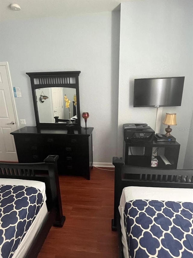 bedroom with dark wood-style flooring