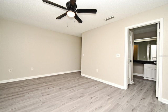 unfurnished bedroom featuring a textured ceiling, ceiling fan, visible vents, baseboards, and light wood finished floors