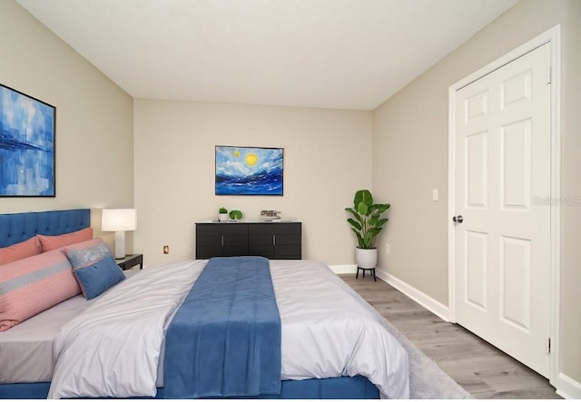 bedroom with light wood-style flooring and baseboards