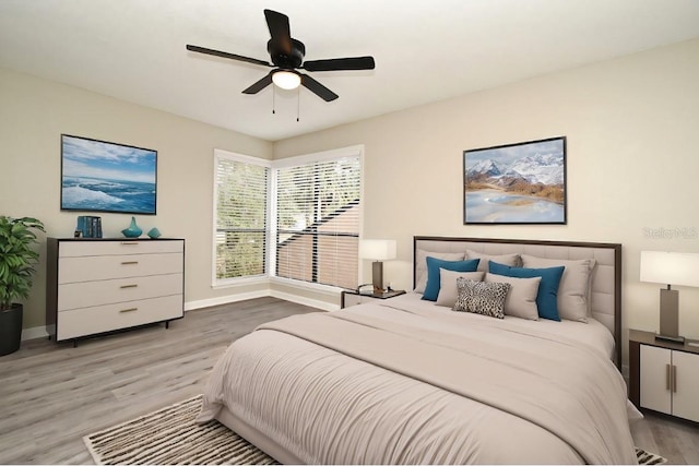 bedroom featuring a ceiling fan, baseboards, and wood finished floors