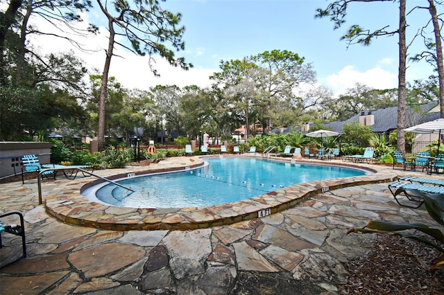 community pool featuring fence and a patio