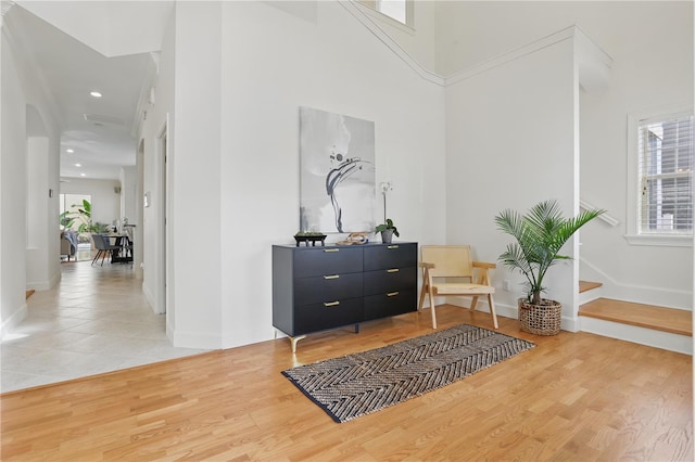 interior space with recessed lighting, baseboards, a high ceiling, and wood finished floors