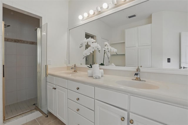 full bath featuring a stall shower, a sink, visible vents, and tile patterned floors