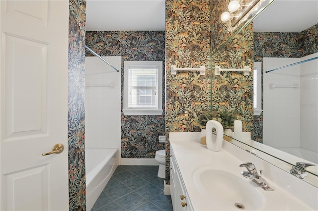 bathroom with toilet, vanity, tile patterned flooring, baseboards, and wallpapered walls