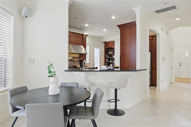 dining area featuring arched walkways, ornamental molding, baseboards, and recessed lighting