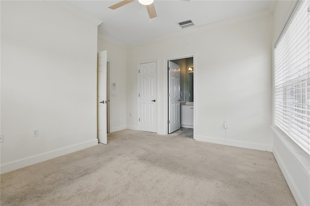 spare room with ornamental molding, visible vents, light carpet, and baseboards