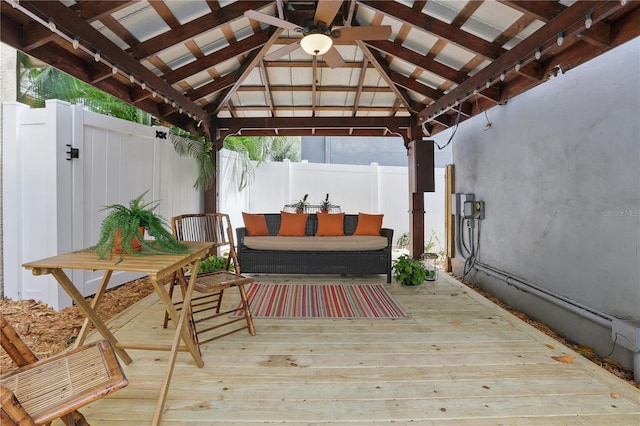 deck featuring ceiling fan, a gazebo, an outdoor hangout area, and a fenced backyard