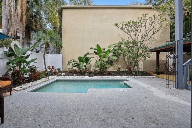 pool with a patio and fence