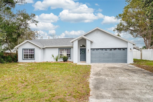 single story home with an attached garage, fence, a front lawn, and concrete driveway