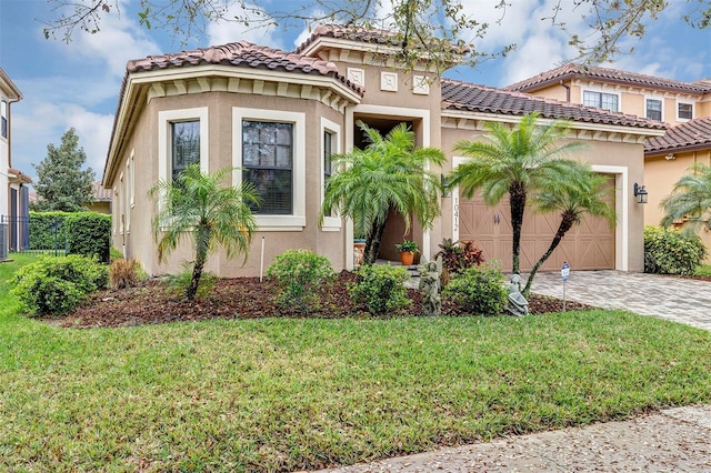 mediterranean / spanish-style home with a garage, a front lawn, and stucco siding