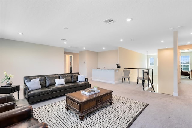 living area featuring light carpet, baseboards, visible vents, and recessed lighting