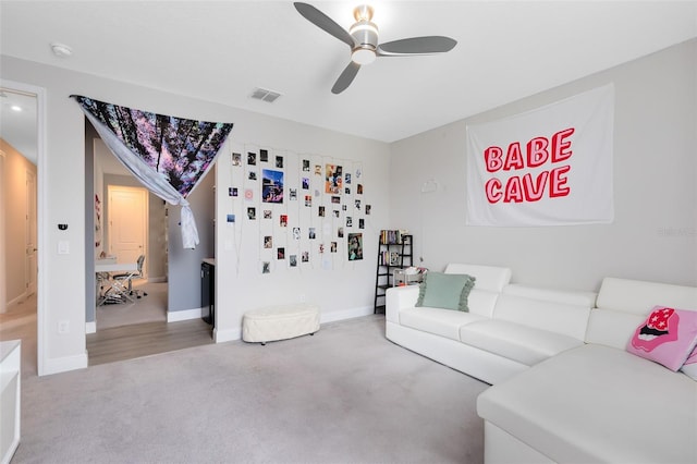 living room with ceiling fan, carpet floors, visible vents, and baseboards