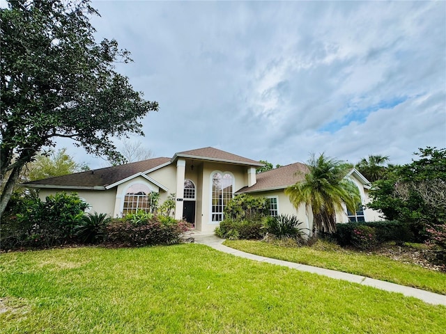 view of front facade with a front lawn and stucco siding