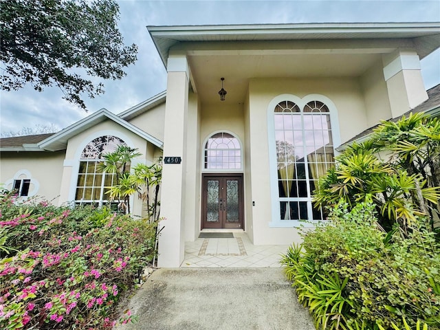 doorway to property featuring french doors and stucco siding