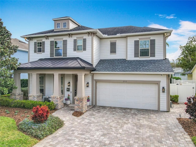 view of front of house with a garage, a shingled roof, metal roof, and decorative driveway