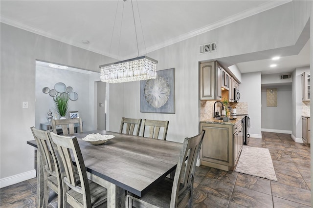 dining room featuring baseboards, visible vents, and crown molding