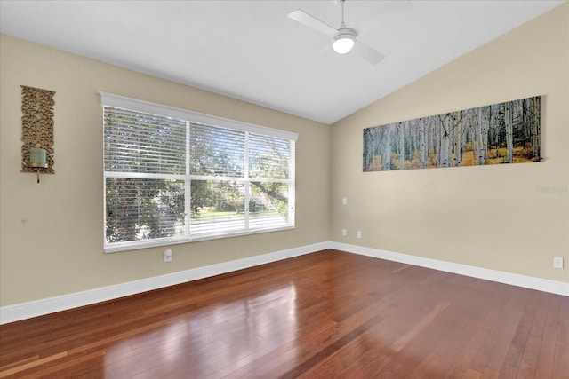 unfurnished room featuring baseboards, vaulted ceiling, and wood finished floors