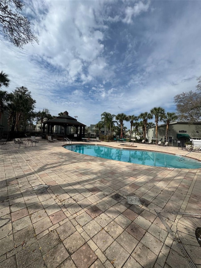 pool with fence, a patio, and a gazebo