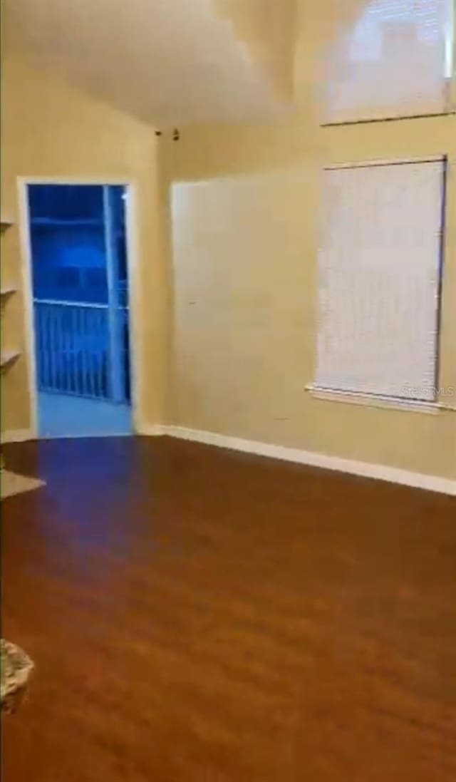 spare room featuring wood finished floors and baseboards