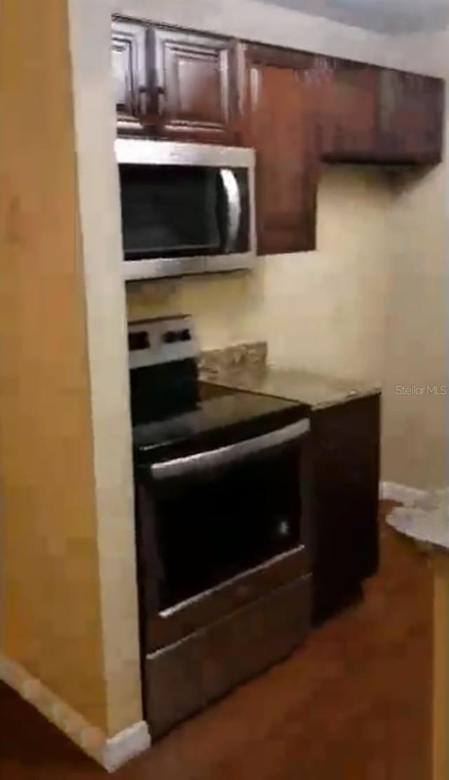 kitchen with appliances with stainless steel finishes, light countertops, and baseboards