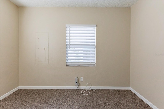 unfurnished room featuring carpet flooring, electric panel, and baseboards