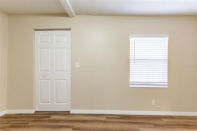 unfurnished room featuring wood finished floors and baseboards