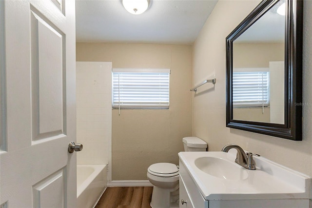 bathroom with toilet, baseboards, wood finished floors, and vanity