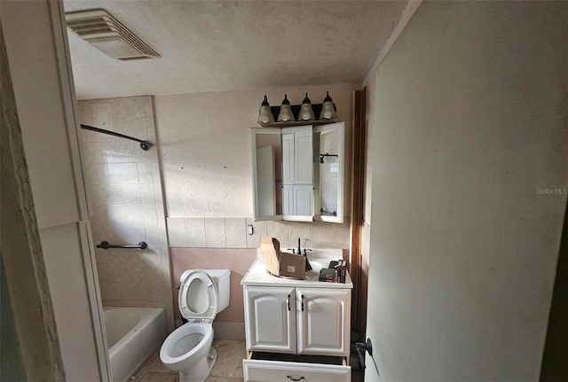 full bathroom featuring tile walls, vanity, tiled shower / bath combo, tile patterned flooring, and toilet