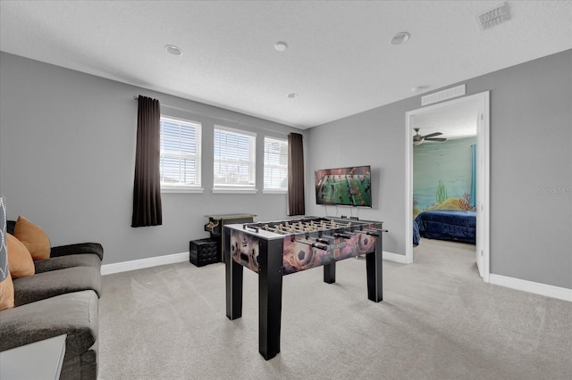 recreation room featuring light carpet, visible vents, and baseboards