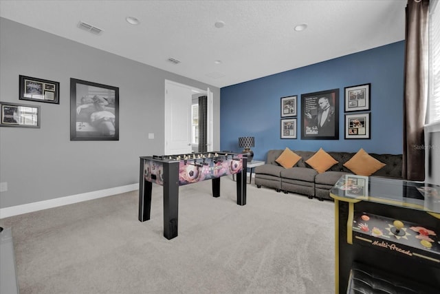 rec room with light carpet, baseboards, visible vents, and a textured ceiling