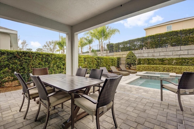 view of patio with outdoor dining area, a fenced backyard, and an in ground hot tub