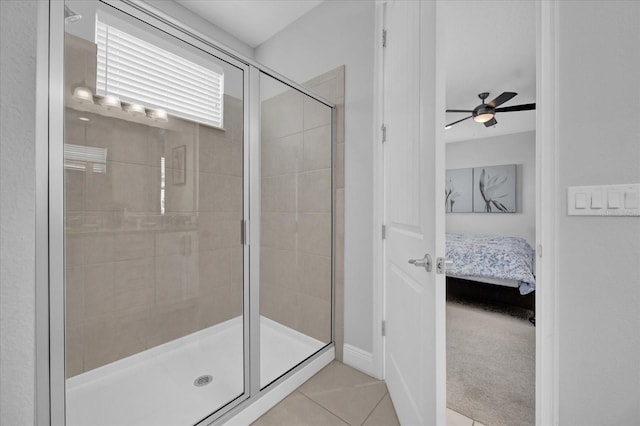 ensuite bathroom with connected bathroom, ceiling fan, tile patterned flooring, and a stall shower