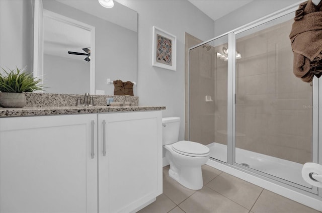 full bath with tile patterned flooring, vanity, toilet, a ceiling fan, and a shower stall