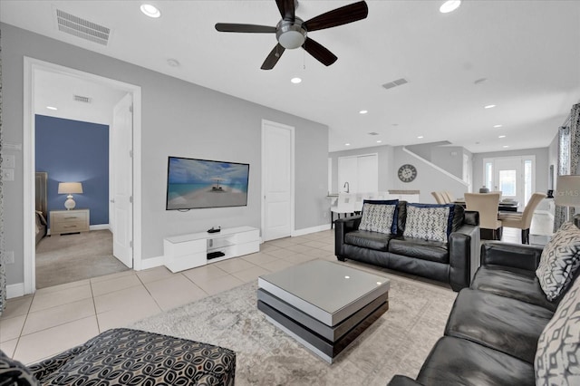 living area with light tile patterned flooring, ceiling fan, and visible vents