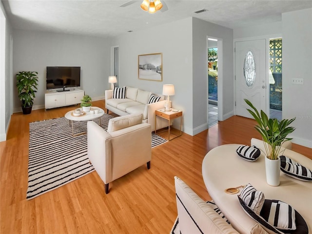 living room with light hardwood / wood-style floors and ceiling fan