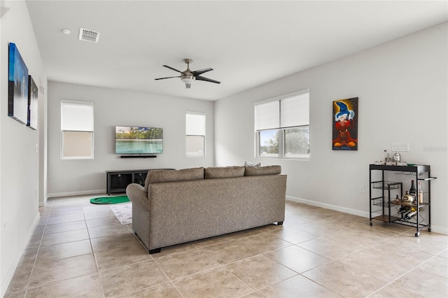 living room featuring ceiling fan, light tile patterned floors, visible vents, and baseboards