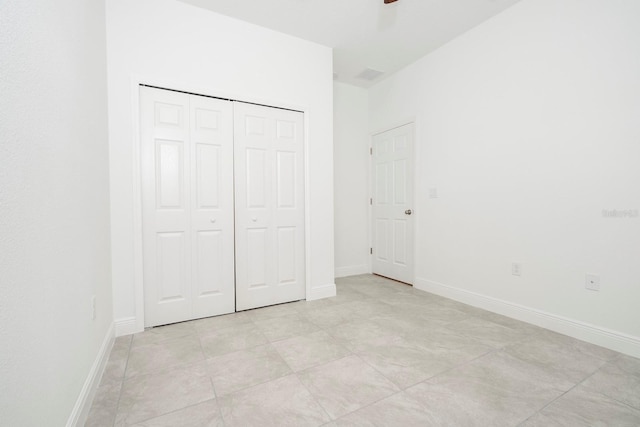 unfurnished bedroom with ceiling fan and a closet