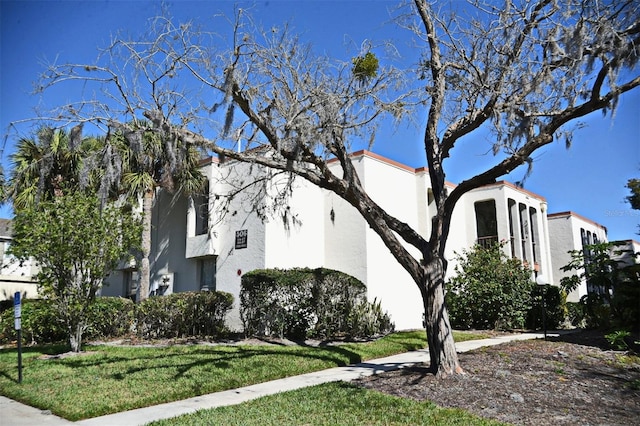 view of property exterior featuring stucco siding and a lawn