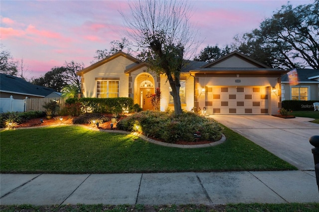 ranch-style home with stucco siding, concrete driveway, an attached garage, fence, and a front lawn