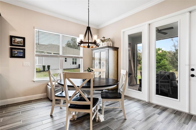 dining room featuring baseboards, a notable chandelier, wood finished floors, and crown molding