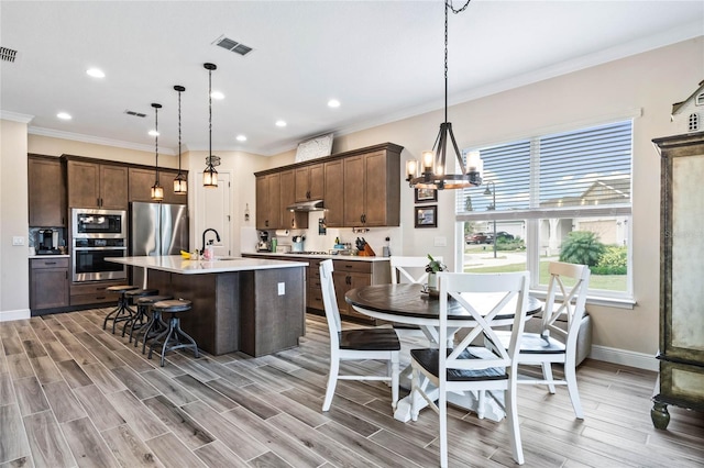 kitchen with light countertops, hanging light fixtures, visible vents, and stainless steel appliances