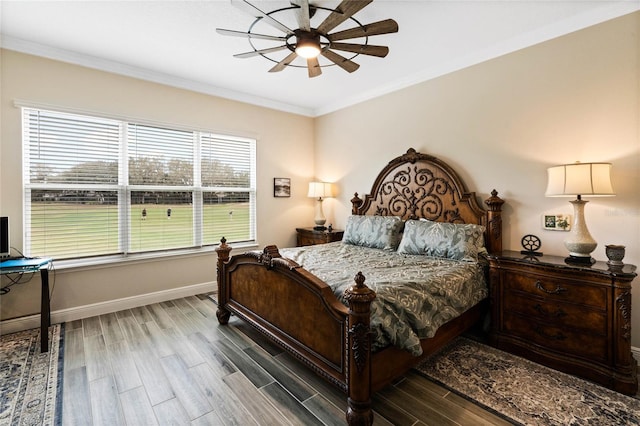 bedroom with baseboards, ceiling fan, wood finished floors, and crown molding