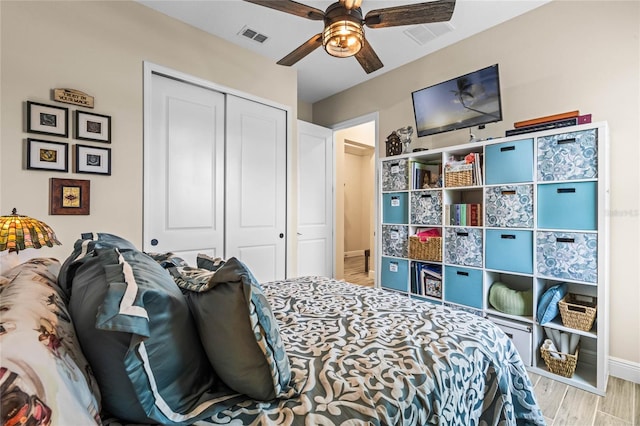 bedroom with a closet, visible vents, light wood-style flooring, ceiling fan, and baseboards