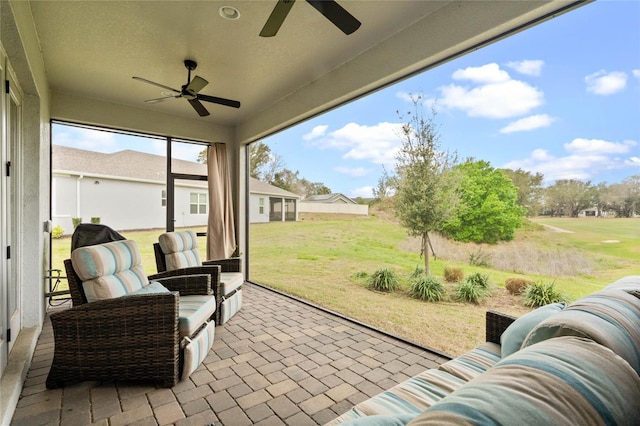 sunroom / solarium featuring ceiling fan