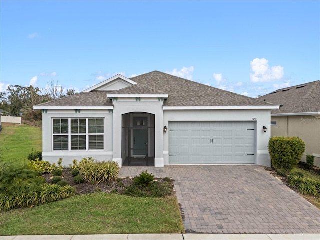 single story home with a shingled roof, decorative driveway, an attached garage, and stucco siding