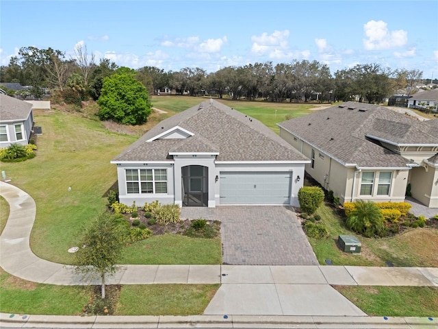 single story home with a garage, a shingled roof, decorative driveway, stucco siding, and a front lawn