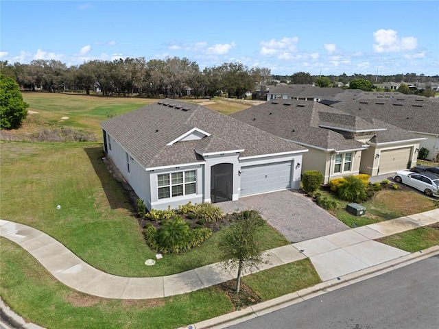 view of front of house featuring a shingled roof, decorative driveway, an attached garage, and stucco siding