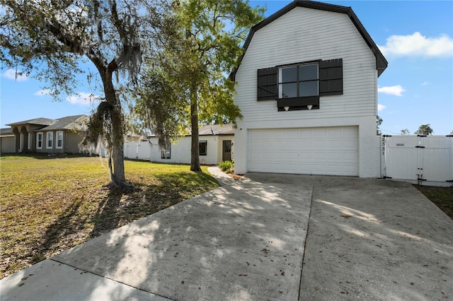 2531 Ludlow St, Deltona, FL 32738 - view of front facade with driveway, a front lawn, a garage, a gambrel roof, and a gate