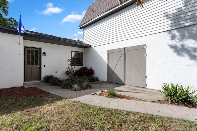 2531 Ludlow St, Deltona, FL 32738 - view of exterior entry featuring stucco siding and a shingled roof