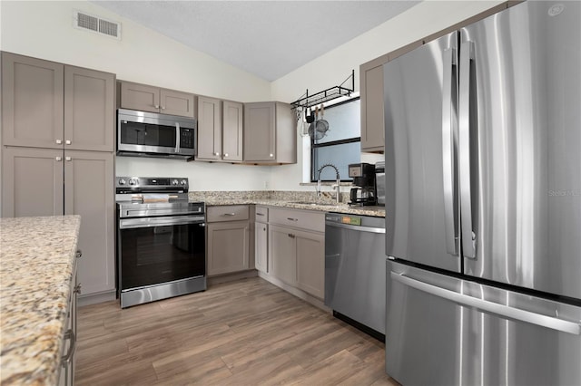 2531 Ludlow St, Deltona, FL 32738 - kitchen with visible vents, a sink, appliances with stainless steel finishes, gray cabinetry, and vaulted ceiling
